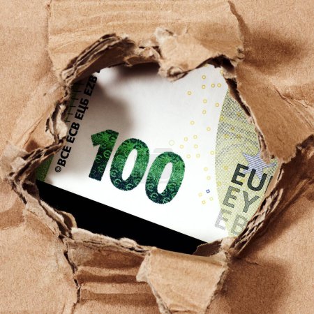 Foto de Billete de cien euros a través del agujero en el fondo de papel - Imagen libre de derechos