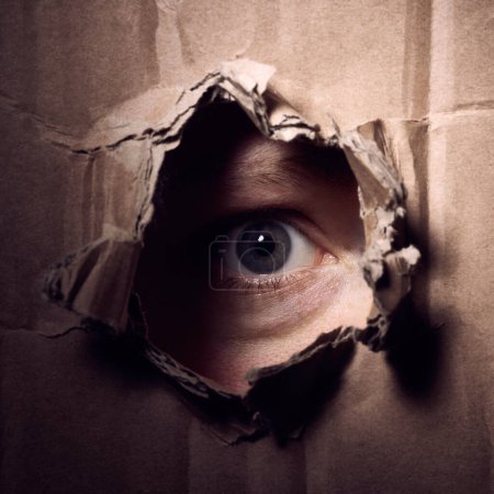 Photo for Scary person looking through a hole in a box - Royalty Free Image