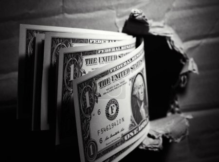 Foto de Billetes de un dólar a través del fondo del dinero del agujero de papel. Concepto de soborno - Imagen libre de derechos