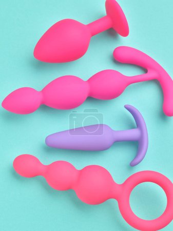 Téléchargez les photos : Eco anal plugs and dildo sex toys over turquoise blue background - en image libre de droit