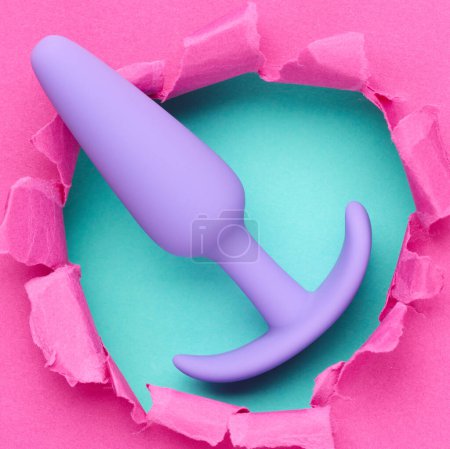 Téléchargez les photos : Anal plug sex toy sur trou dans fond de papier rose - en image libre de droit