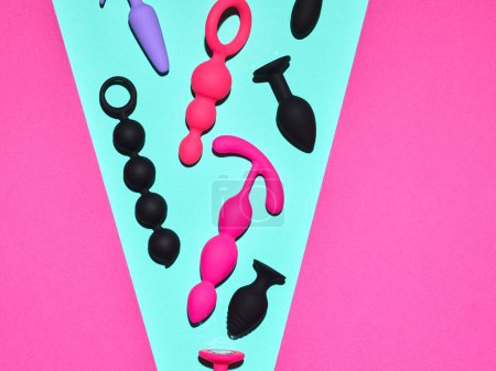 Téléchargez les photos : Sex toys background. Anal plugs and dildo over blue and pink backdrop - en image libre de droit
