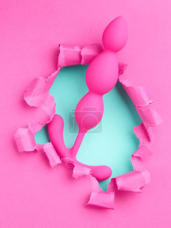 Téléchargez les photos : Sex toy sur le trou dans fond de papier rose - en image libre de droit