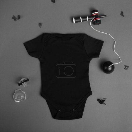 Foto de Nuevo traje de bebé negro sobre fondo gris. Color pastel. Lugar vacío para texto o logotipo en la ropa. Plantilla falsa. Bebé manga corta maqueta - Imagen libre de derechos