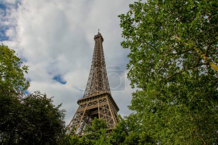 Photo for The Eiffel Tower on the background of clouds and trees, in summer - Royalty Free Image