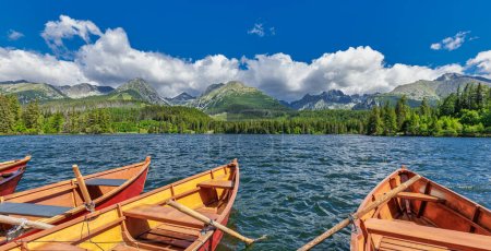 Téléchargez les photos : Tranquille vue panoramique du matin sur les montagnes des Hautes Tatras. Parc national forestier, lac Strbske en Slovaquie. Paysage naturel incroyable, ciel bleu ensoleillé, bateaux en bois. Tranquille liberté fond d'aventure - en image libre de droit
