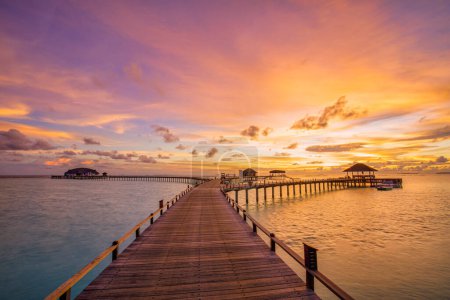 Téléchargez les photos : Incroyable paysage de plage. Beau coucher de soleil Maldives vue sur le paysage marin. Horizon nuages de ciel de mer colorés, sur le chemin de jetée de villa d'eau. Tranquille lagune de l'île, tourisme de fond Voyage. Vacances exotiques - en image libre de droit