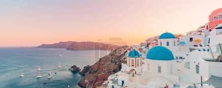 Photo for Fantastic Mediterranean Santorini island, Greece. Amazing romantic sunrise in Oia background, morning light. Amazing sunset view with white houses blue domes. Panoramic travel landscape. Lovers island - Royalty Free Image