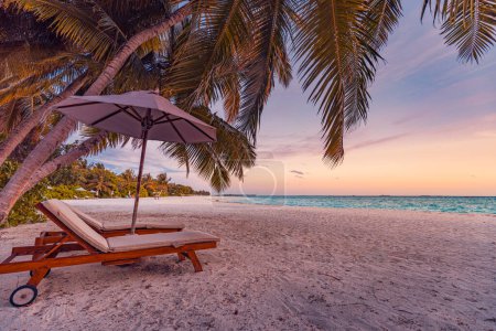 Photo for Love couple amazing beach. Sunny umbrella and lounge chairs beds close to sea under palm leaves. Summer relax coast landscape, leisure inspire honeymoon vacation, romantic lifestyle. Freedom travel - Royalty Free Image