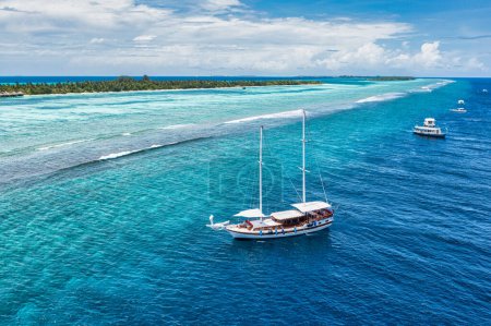 Photo for Luxury island landscape in Maldives. Sail boat blue sea water horizon reef water villas. Tropical beach amazing aerial seascape view from drone. Beautiful nature people snorkel excursion, recreation - Royalty Free Image
