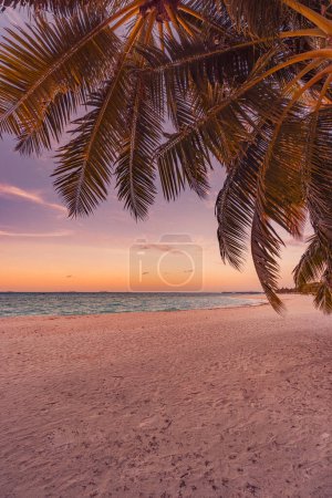 Foto de Fantástica vista de cerca de palmeras solitarias olas de agua de mar tranquilas con cielo naranja al atardecer. Isla tropical playa paisaje, costa exótica. Naturaleza de verano escénica. Relájese costa paraíso - Imagen libre de derechos