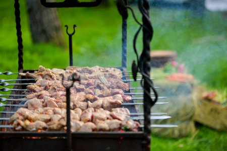 Foto de Cocinar carne en pinchos en una barbacoa a la parrilla en el jardín de verano. - Imagen libre de derechos