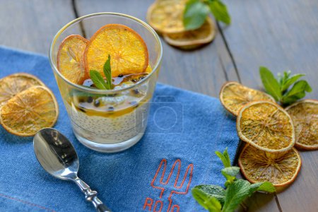 Téléchargez les photos : Fruits du désert orange en verre avec des tranches d'orange menthe fraîche et des graines de chia. - en image libre de droit