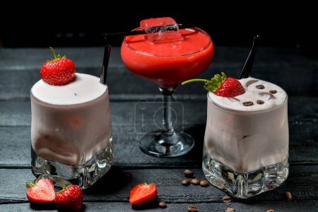 Téléchargez les photos : Cocktails dans un verre aux fraises sur fond noir avec décor - en image libre de droit