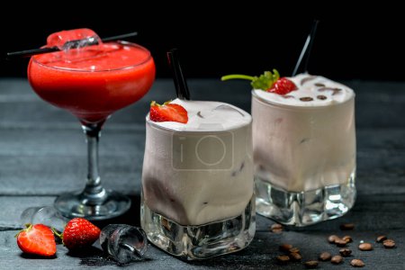 Téléchargez les photos : Cocktails dans un verre aux fraises sur fond noir avec décor - en image libre de droit