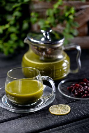 Photo for Green matcha tea in a teapot and cup  on a black background - Royalty Free Image