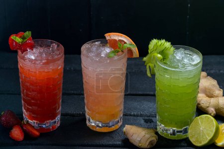 Téléchargez les photos : Trois verres de cocktails sur fond sombre - en image libre de droit