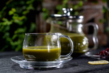 Téléchargez les photos : Thé matcha vert dans une théière et une tasse sur un fond noir - en image libre de droit