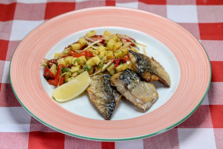 Téléchargez les photos : Assiette avec poisson maquereau frit aux légumes sur la table - en image libre de droit