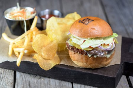 Photo for Big burger with falafel on a board with french fries - Royalty Free Image
