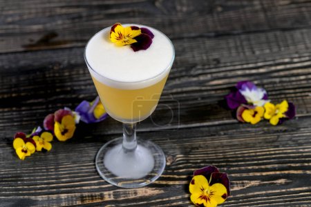 Téléchargez les photos : Cocktail alcoolisé jaune décoré de fleurs sur le plateau - en image libre de droit