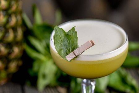 Photo for Green cocktail on a wooden board with basil leaves and pineapple - Royalty Free Image