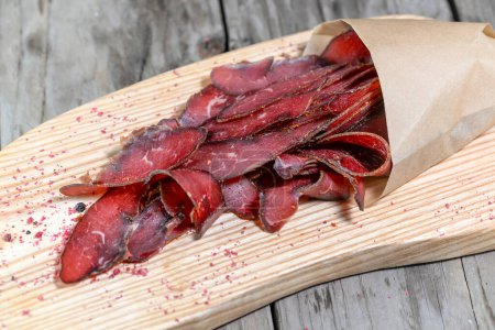 Photo for Portion of Beef Jerky on wooden background - Royalty Free Image