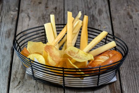 Téléchargez les photos : Panier avec de savoureuses frites, chips et pain sur table en bois - en image libre de droit