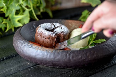 Téléchargez les photos : Délicieuse crème glacée avec gâteau au chocolat et main féminine - en image libre de droit