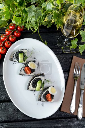 Photo for Bruschetta with black caviar ,tomato,cucumber and wine - Royalty Free Image