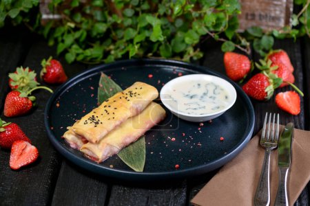 Foto de Panqueques recién horneados con queso y fresas sobre fondo oscuro - Imagen libre de derechos