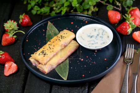 Téléchargez les photos : Crêpes fraîches cuites au four avec fromage et fraises sur fond sombre - en image libre de droit