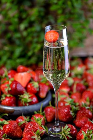 Photo for Glass of champagne with strawberries on background, close up - Royalty Free Image