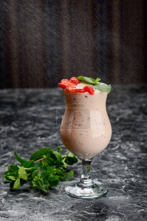 Téléchargez les photos : Boisson au lait de fraise dans un verre sur la table - en image libre de droit