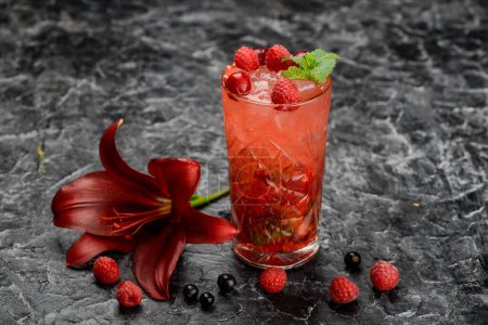 Photo for Apples and raspberries lemonade in glass on a table with a red lily - Royalty Free Image