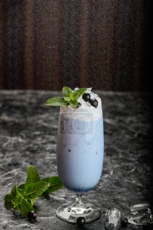 Téléchargez les photos : Milkshake aux bleuets dans un verre avec glace sur la table - en image libre de droit