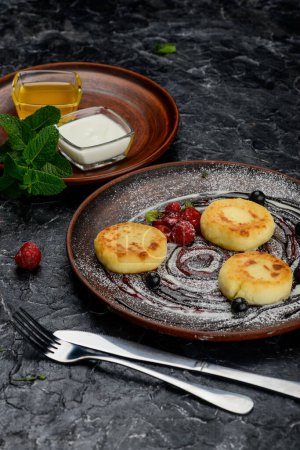 Foto de Tartas de queso caseras con crema, bayas y menta. - Imagen libre de derechos