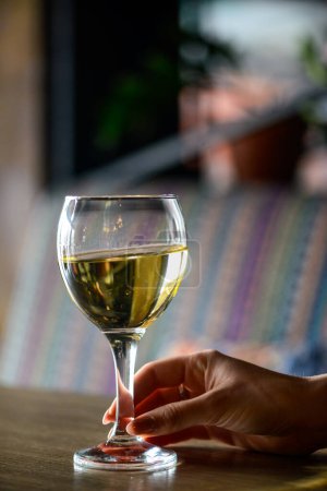 Photo for Glass of white wine in female hand on background, close up - Royalty Free Image