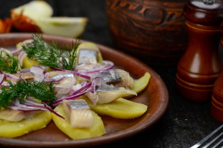 Photo for Herring fillet on potatoes with onions in a plate - Royalty Free Image