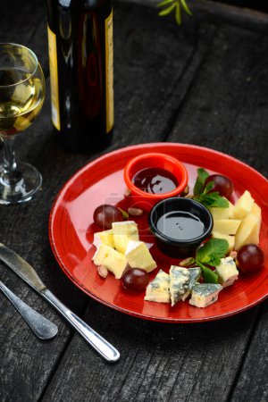 Téléchargez les photos : Assiette avec fromage savoureux et vin sur fond en bois - en image libre de droit