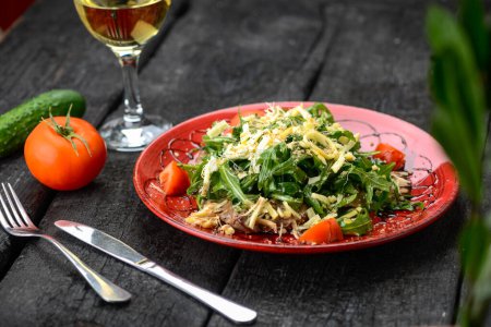 Téléchargez les photos : Salade géorgienne avec roquette, fromage et viande dans une assiette avec vin - en image libre de droit