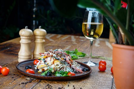 Téléchargez les photos : Salade de légumes géorgienne dans une assiette en argile sur fond de bois avec tomates et légumes verts - en image libre de droit