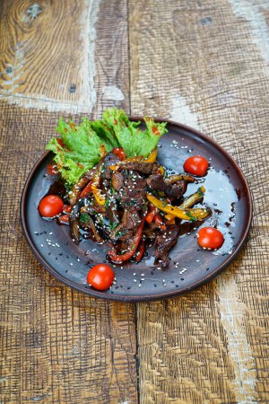 Photo for Fried veal meat with peppers and cherry tomatoes in a plate - Royalty Free Image