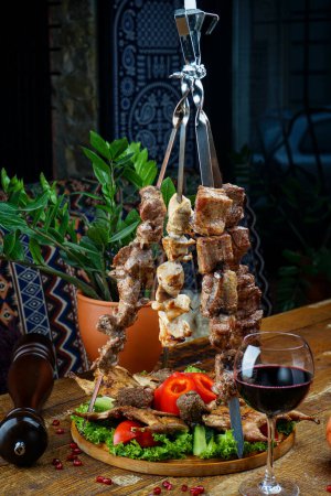Photo for Georgian kebab on skewers on the table with wine - Royalty Free Image