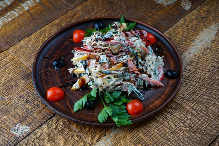 Téléchargez les photos : Salade de légumes géorgienne dans une assiette en argile sur un fond en bois - en image libre de droit
