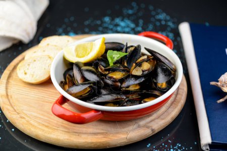 Photo for Boiled mussels in a plate with lemon and bruschetta - Royalty Free Image