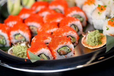Foto de Rollos de sushi con salmón, aguacate, caviar en el plato - Imagen libre de derechos