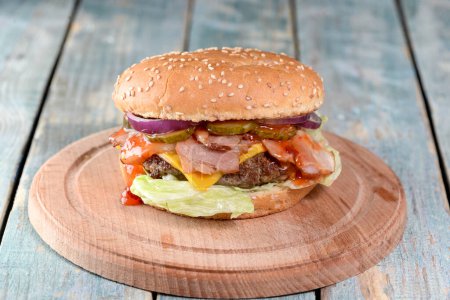 Photo for Homemade hamburger with cheese, onions, tomato, onion, lettuce  on table - Royalty Free Image