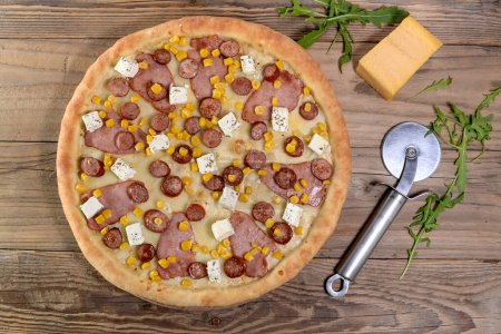 Foto de Pizza de pepperoni picante con carne, champiñones, salchichas, maíz, rúcula y queso - Imagen libre de derechos