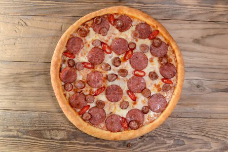 Foto de Pizza de pepperoni picante con salami y pimientos en el fondo, de cerca - Imagen libre de derechos
